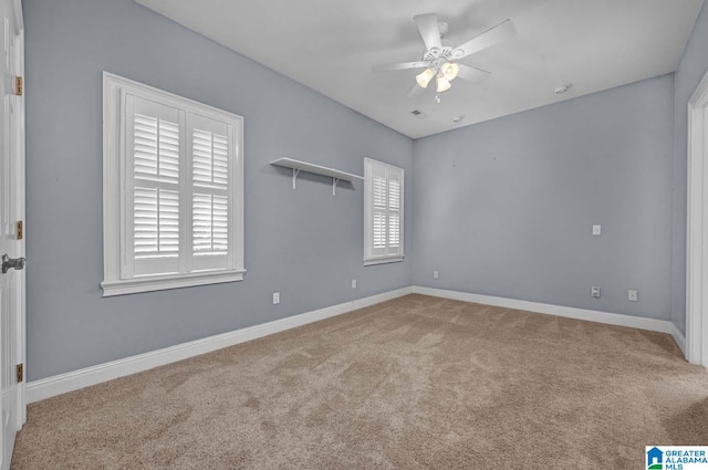 empty room with ceiling fan and light carpet