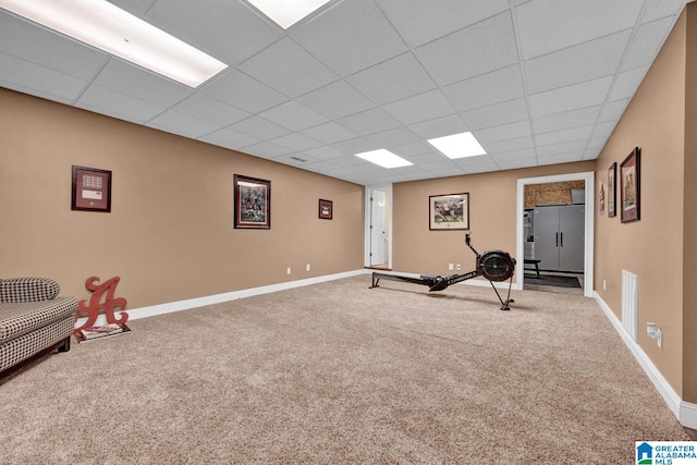 workout room featuring a paneled ceiling and carpet