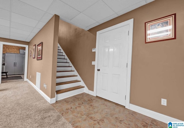 tiled foyer entrance with a paneled ceiling