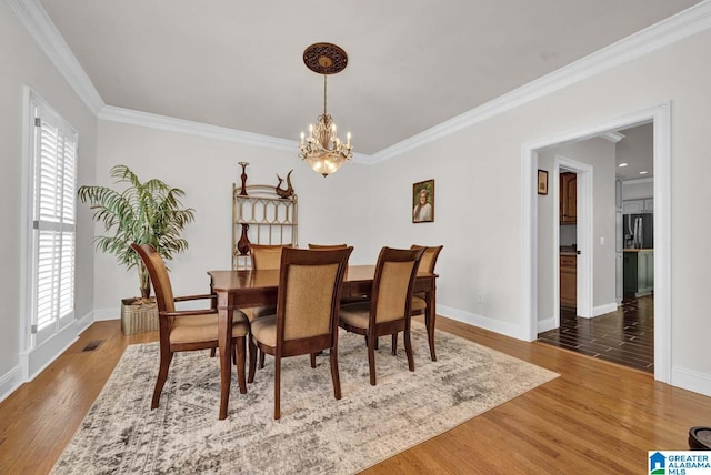 dining room featuring crown molding, dark wood-type flooring, and a wealth of natural light