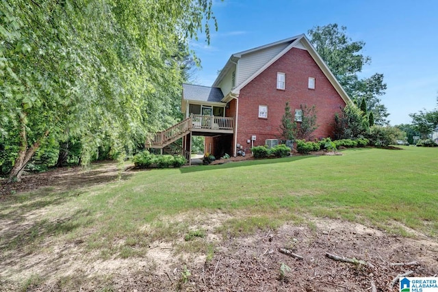 rear view of house featuring a lawn, central AC, and a deck