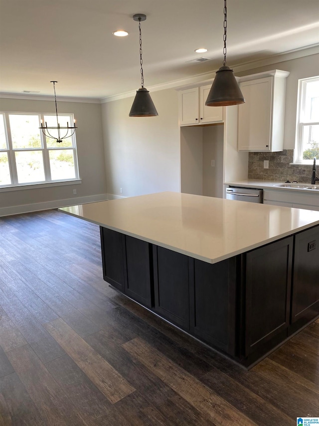 kitchen featuring decorative light fixtures, white cabinets, a kitchen island, and dark hardwood / wood-style floors