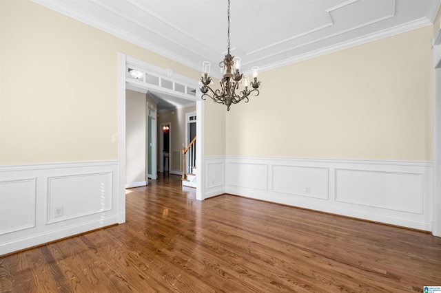 empty room with ornamental molding, dark wood-type flooring, and an inviting chandelier