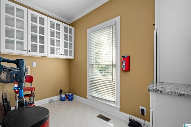 workout area featuring crown molding