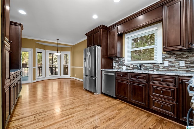 kitchen featuring a healthy amount of sunlight, stainless steel appliances, and light wood-type flooring