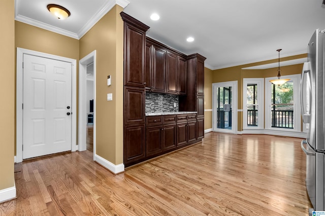 kitchen with dark brown cabinetry, backsplash, stainless steel refrigerator, and light hardwood / wood-style flooring