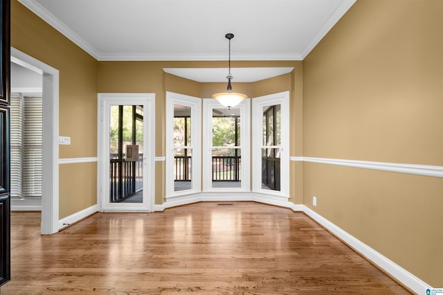 entryway with ornamental molding and light hardwood / wood-style floors