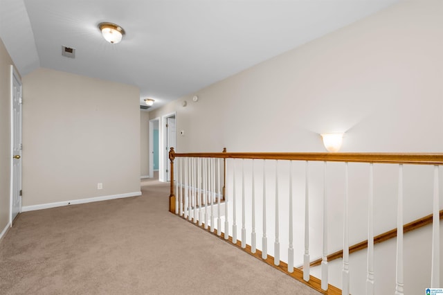 hall with lofted ceiling and light colored carpet