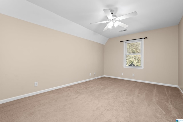 spare room with lofted ceiling, light colored carpet, and ceiling fan