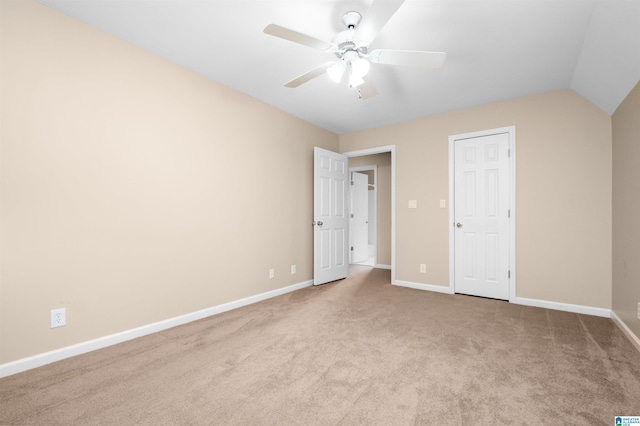 unfurnished bedroom featuring light colored carpet, lofted ceiling, and ceiling fan