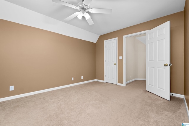 unfurnished bedroom featuring lofted ceiling, ceiling fan, and light carpet