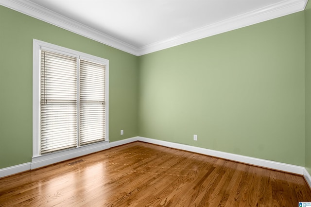 spare room with ornamental molding and hardwood / wood-style floors