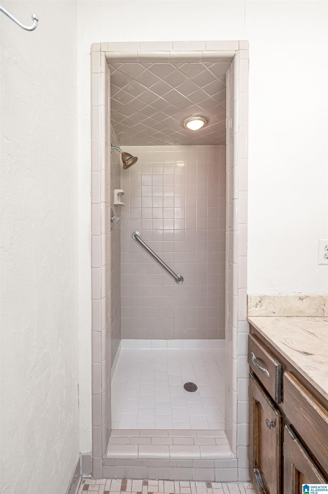 bathroom with vanity and a tile shower