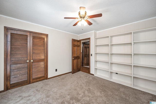 unfurnished bedroom with crown molding, carpet flooring, a closet, ceiling fan, and a textured ceiling