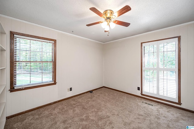 carpeted empty room with crown molding, a textured ceiling, and ceiling fan