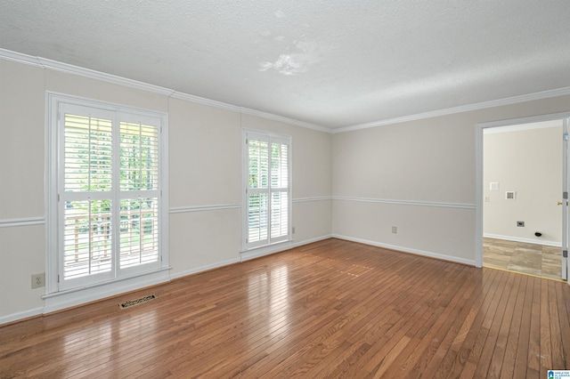 spare room featuring crown molding, a textured ceiling, and hardwood / wood-style flooring