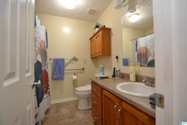 bathroom with toilet, a textured ceiling, and vanity