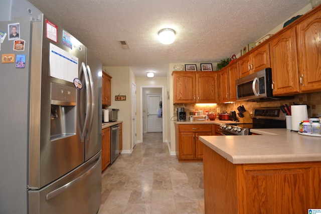 kitchen with a textured ceiling, backsplash, stainless steel appliances, and kitchen peninsula