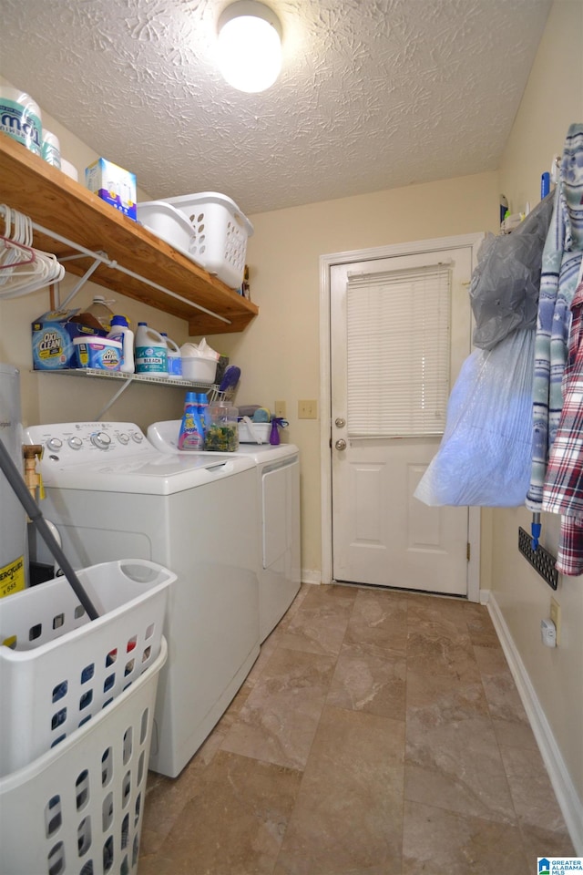 laundry room with a textured ceiling and separate washer and dryer