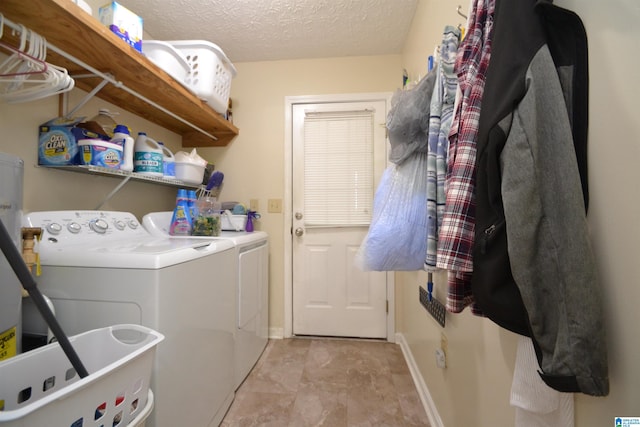 laundry room featuring washing machine and clothes dryer and a textured ceiling