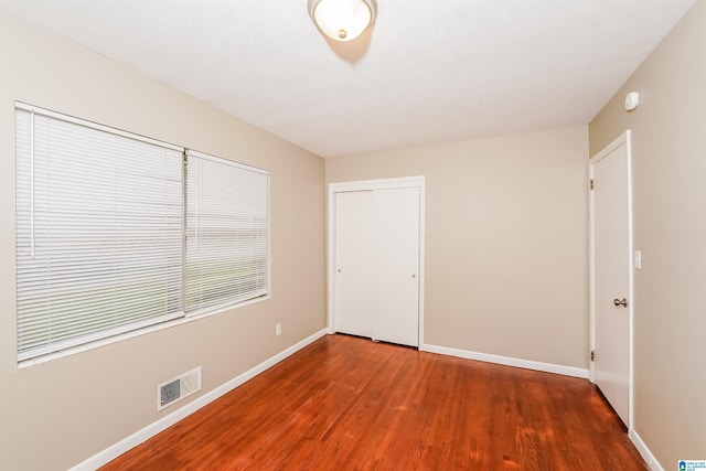 unfurnished bedroom with a closet and wood-type flooring