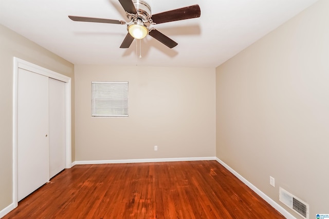 unfurnished bedroom with ceiling fan, a closet, and hardwood / wood-style flooring