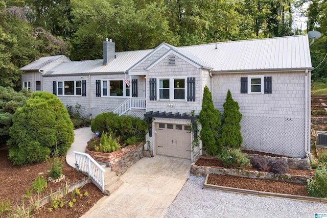 ranch-style house featuring cooling unit and a garage