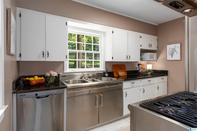 kitchen with light tile patterned floors, appliances with stainless steel finishes, sink, and white cabinetry