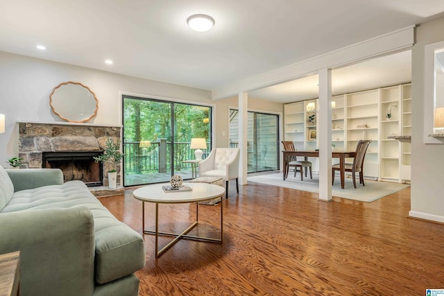 living room with recessed lighting, wood finished floors, and a fireplace