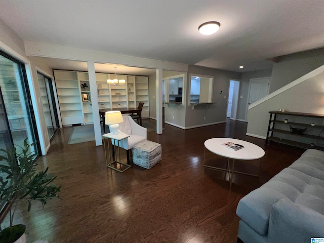 living room with dark wood-type flooring and an inviting chandelier