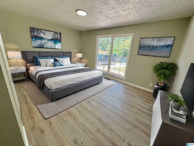 bedroom featuring light wood-type flooring and a textured ceiling