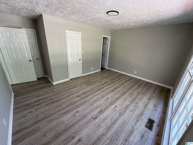 unfurnished bedroom featuring hardwood / wood-style floors and a textured ceiling