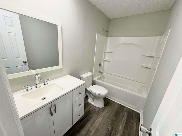 full bathroom with a textured ceiling, vanity, shower / washtub combination, hardwood / wood-style floors, and toilet