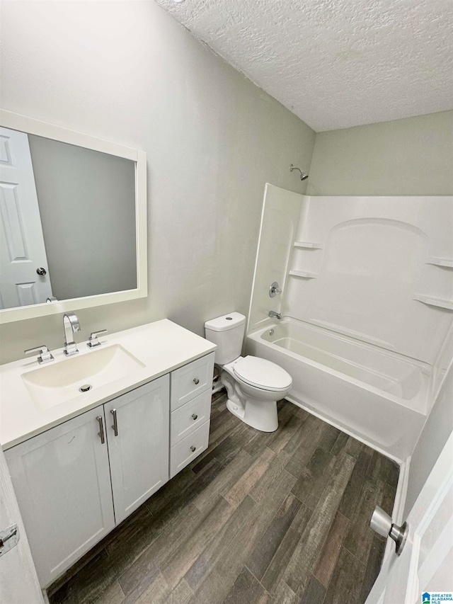 full bathroom featuring a textured ceiling, vanity, shower / tub combination, hardwood / wood-style floors, and toilet