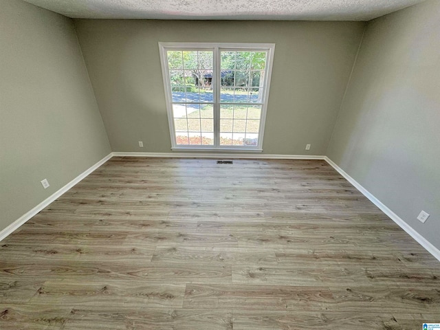 unfurnished room featuring a textured ceiling and wood-type flooring