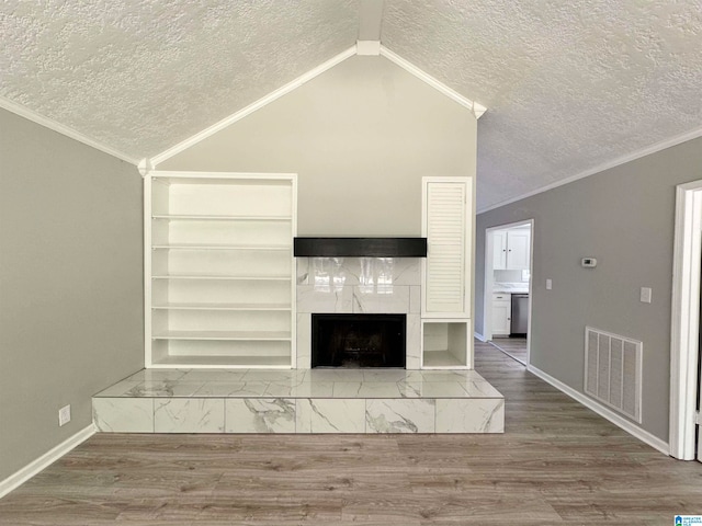 unfurnished living room with crown molding, a textured ceiling, a fireplace, and hardwood / wood-style floors