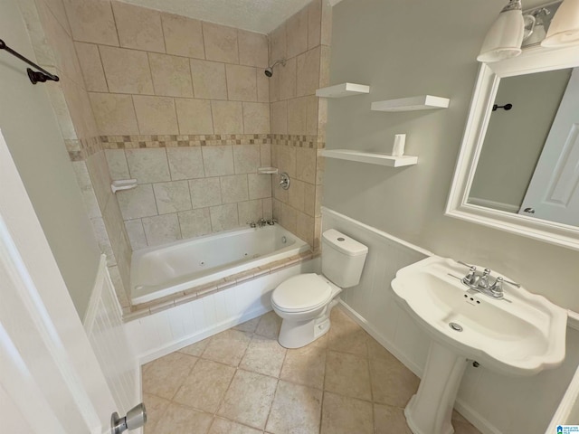 full bathroom with tiled shower / bath, sink, tile patterned floors, and toilet