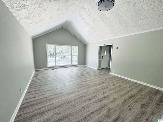 additional living space with a textured ceiling, dark wood-type flooring, and lofted ceiling