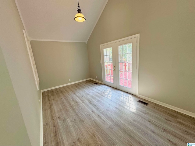 unfurnished room with light wood-type flooring, high vaulted ceiling, and french doors