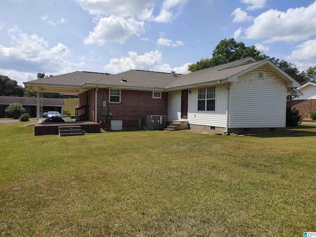 rear view of house with a yard and central air condition unit