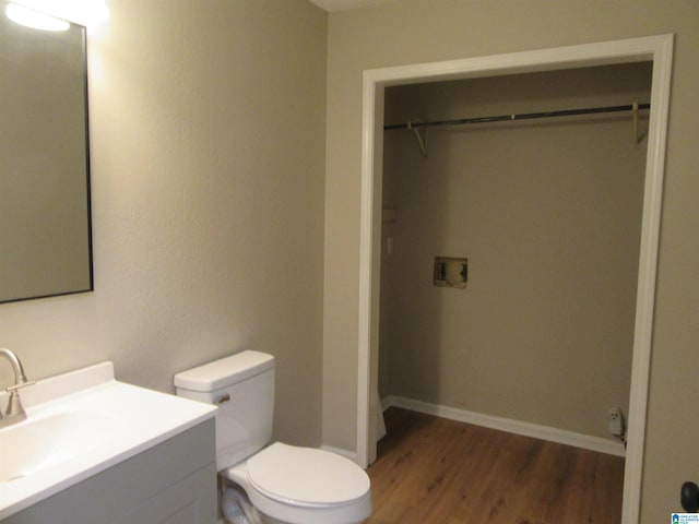 bathroom featuring toilet, hardwood / wood-style flooring, and vanity