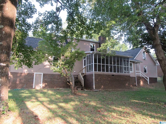 back of property featuring a yard and a sunroom