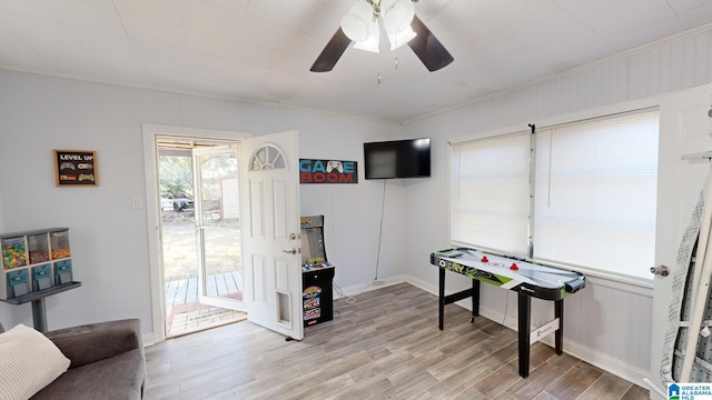 playroom featuring light wood-type flooring, ceiling fan, and ornamental molding