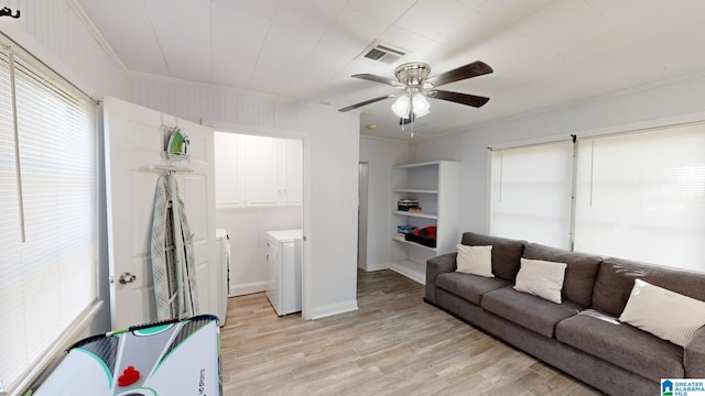 living room featuring light hardwood / wood-style flooring, ceiling fan, ornamental molding, and washer and dryer