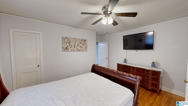 bedroom featuring ceiling fan, hardwood / wood-style flooring, and a textured ceiling