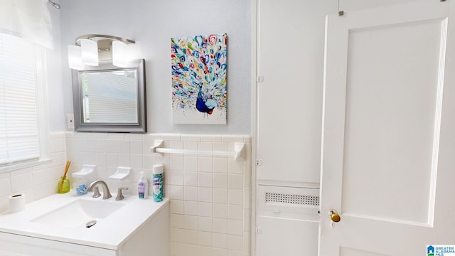 bathroom featuring vanity, tile walls, and tasteful backsplash