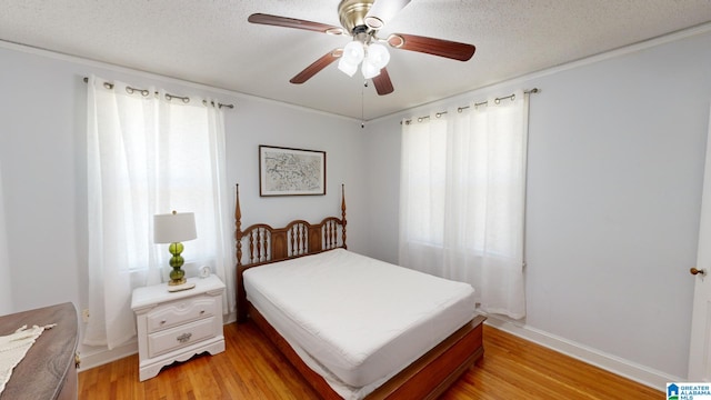 bedroom with multiple windows, a textured ceiling, light hardwood / wood-style flooring, and ceiling fan