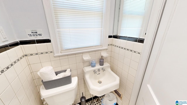 bathroom with tile walls, toilet, and sink