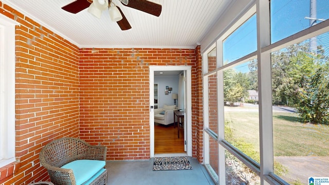 unfurnished sunroom with ceiling fan