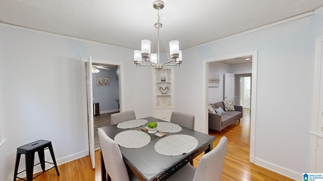 dining room featuring ceiling fan with notable chandelier, a textured ceiling, and light hardwood / wood-style flooring